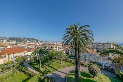 a view of a city with palm trees and buildings at IMMOGROOM - Sea view - Swimming Pool - Terrace- Clim in Cannes