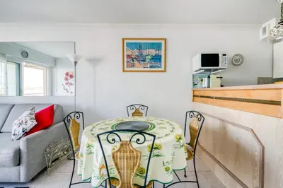 a dining room with a table and a couch at IMMOGROOM - Sea view - Swimming Pool - Terrace- Clim in Cannes