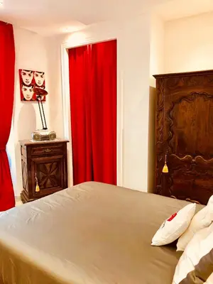 a bedroom with a bed and a red curtain at Apartment 3 Pieces in Cannes