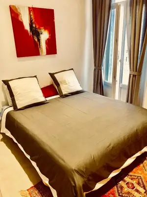 a large bed in a room with a window at Apartment 3 Pieces in Cannes