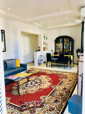 a living room with a blue couch and a red rug at Apartment 3 Pieces in Cannes