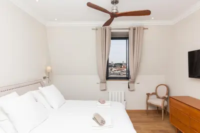 a bedroom with a white bed and a window at Appartement vue Mer, Suquet et Palais avec parking in Cannes