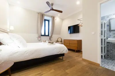 a bedroom with a large bed and a tv at Appartement vue Mer, Suquet et Palais avec parking in Cannes