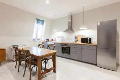 a kitchen with a table and chairs and a refrigerator at Appartement vue Mer, Suquet et Palais avec parking in Cannes