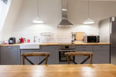 a kitchen with a wooden table and two chairs at Appartement vue Mer, Suquet et Palais avec parking in Cannes