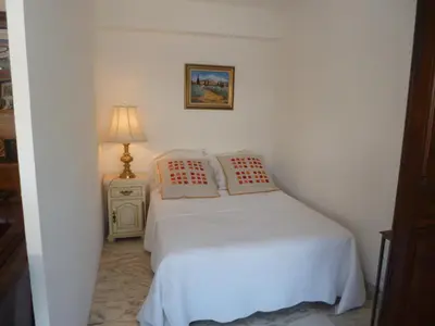 a small bedroom with a white bed and a lamp at Résidence Le Président - Forville in Cannes