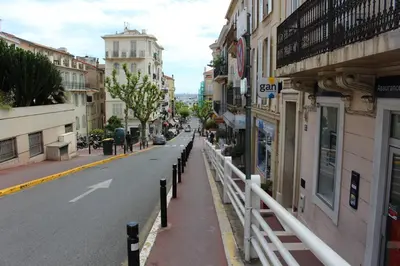 a city street with buildings and a white fence at Résidence Le Président - Forville in Cannes