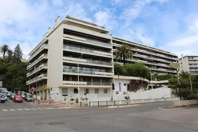 a large white building on the corner of a street at Résidence Le Président - Forville in Cannes