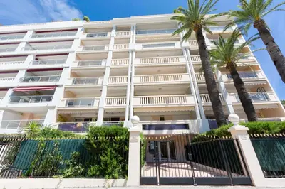 a kitchen with white cabinets and a black and white tile floor at Apartment 2 bedrooms2 bathroomsdouble terrace & Garden in Palm beach area in Cannes