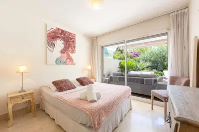 an outdoor patio with a glass table and chairs at Apartment 2 bedrooms2 bathroomsdouble terrace & Garden in Palm beach area in Cannes