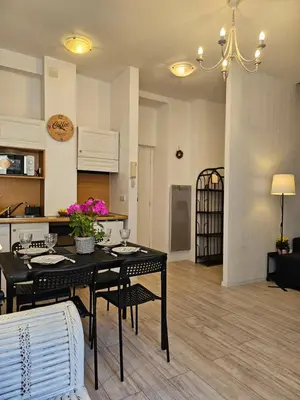 a living room with a table and chairs and a kitchen at SUQUET - BEACH 100m & PALAIS DES FESTIVALS 600m in Cannes