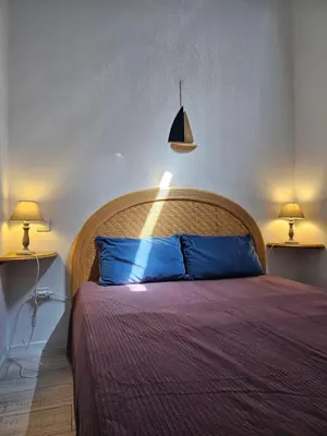 a bedroom with a bed with blue pillows and two lamps at SUQUET - BEACH 100m & PALAIS DES FESTIVALS 600m in Cannes