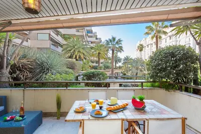 a table on a balcony with food on it at Gray d'Albion YourHostHelper in Cannes