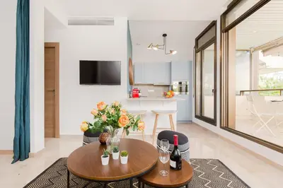 a living room with two tables and a kitchen at Gray d'Albion YourHostHelper in Cannes