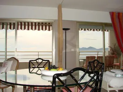 a dining room with a glass table and chairs at Cannes Sea View in Cannes