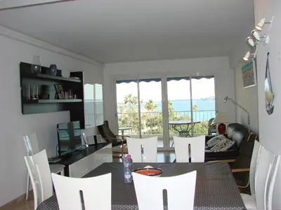 a living room with a table and white chairs at Cannes Sea View in Cannes