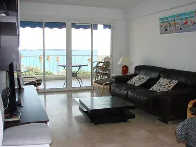 a living room with a black leather couch and a table at Cannes Sea View in Cannes