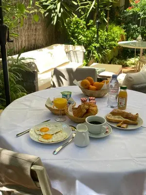 a table with breakfast food on a white table cloth at Hôtel Jardin Croisette in Cannes