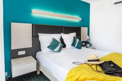 a bedroom with a bed with a hat on it at Hôtel Jardin Croisette in Cannes