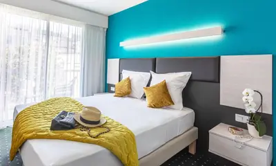 a hotel room with a bed with a hat on it at Hôtel Jardin Croisette in Cannes