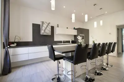 a kitchen with a table and black chairs at Cannes Spacious 4 Bedroom Apartment with Sunny Terrace in Cannes