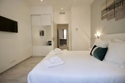 a bedroom with a large white bed with towels on it at Cannes Spacious 4 Bedroom Apartment with Sunny Terrace in Cannes