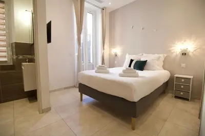 a bedroom with a large bed with white sheets and pillows at Cannes Spacious 4 Bedroom Apartment with Sunny Terrace in Cannes
