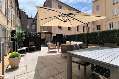 a patio with a table and an umbrella at Cannes Spacious 4 Bedroom Apartment with Sunny Terrace in Cannes