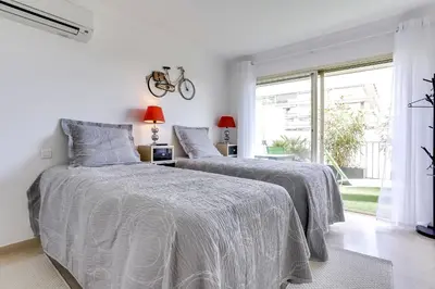 two beds in a white bedroom with a window at IMMOGROOM - Apartment with terrace - AC - Parking in Cannes