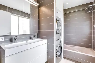 a bathroom with a sink and a washing machine at IMMOGROOM - Apartment with terrace - AC - Parking in Cannes
