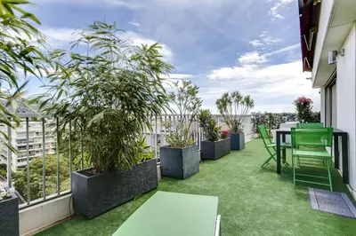 a balcony with plants and a table and chairs at IMMOGROOM - Apartment with terrace - AC - Parking in Cannes