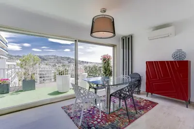 a dining room with a glass table and a large window at IMMOGROOM - Apartment with terrace - AC - Parking in Cannes