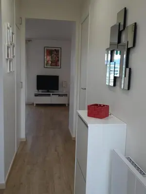 a living room with white walls and a television at VUE MER - Appartement T2 in Cannes