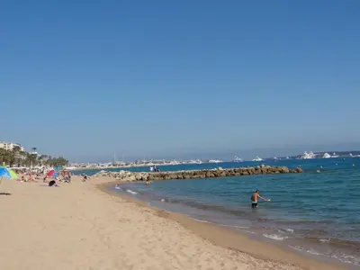 a person standing in the water on a beach at VUE MER - Appartement T2 in Cannes