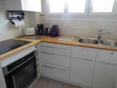 a kitchen with white cabinets and a sink at VUE MER - Appartement T2 in Cannes
