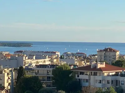 a city with buildings and the ocean in the background at VUE MER - Appartement T2 in Cannes