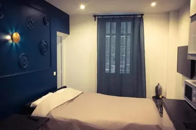 a bedroom with a bed with a blue wall and a window at Delaup Sea Cannes in Cannes