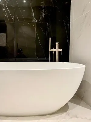 a white bath tub sitting in a bathroom at Grand 2 pieces Gray d'Albion in Cannes