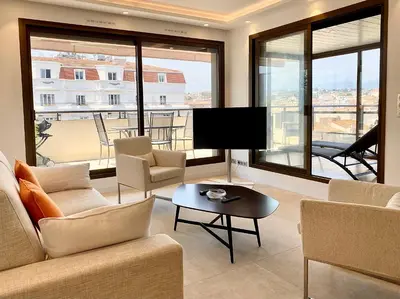 a living room with a couch and chairs and a television at Grand 2 pieces Gray d'Albion in Cannes