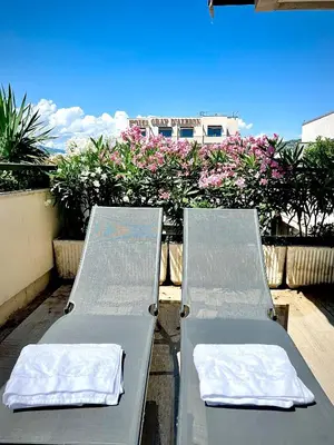 two beds sitting on a balcony with pink flowers at Grand 2 pieces Gray d'Albion in Cannes