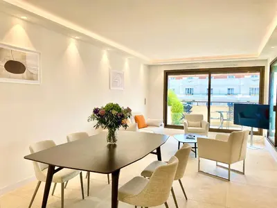 a living room with a table and chairs and a television at Grand 2 pieces Gray d'Albion in Cannes