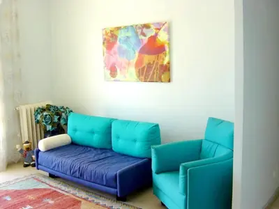 a living room with a blue couch and a painting at Appartement moderne à Cannes avec vue sur mer et montagne - 85 m² in Cannes