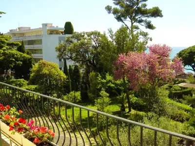 a garden with flowers and trees and a building at Appartement moderne à Cannes avec vue sur mer et montagne - 85 m² in Cannes