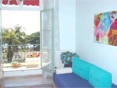 a living room with a blue couch in front of a window at Appartement moderne à Cannes avec vue sur mer et montagne - 85 m² in Cannes