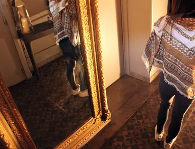 a woman standing in front of a mirror at 7Art Hotel in Cannes