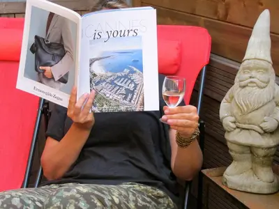 a woman sitting in a chair holding a glass of wine at 7Art Hotel in Cannes