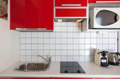 a kitchen with red cabinets and a sink at Frères Suquet Sea Cannes in Cannes