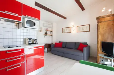 a kitchen with red cabinets and a couch in a room at Frères Suquet Sea Cannes in Cannes