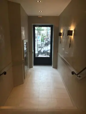 a hallway with a door and a tile floor at Eve in Cannes