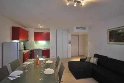 a kitchen and a living room with a table and a couch at Le Vieux Port Apartments in Cannes